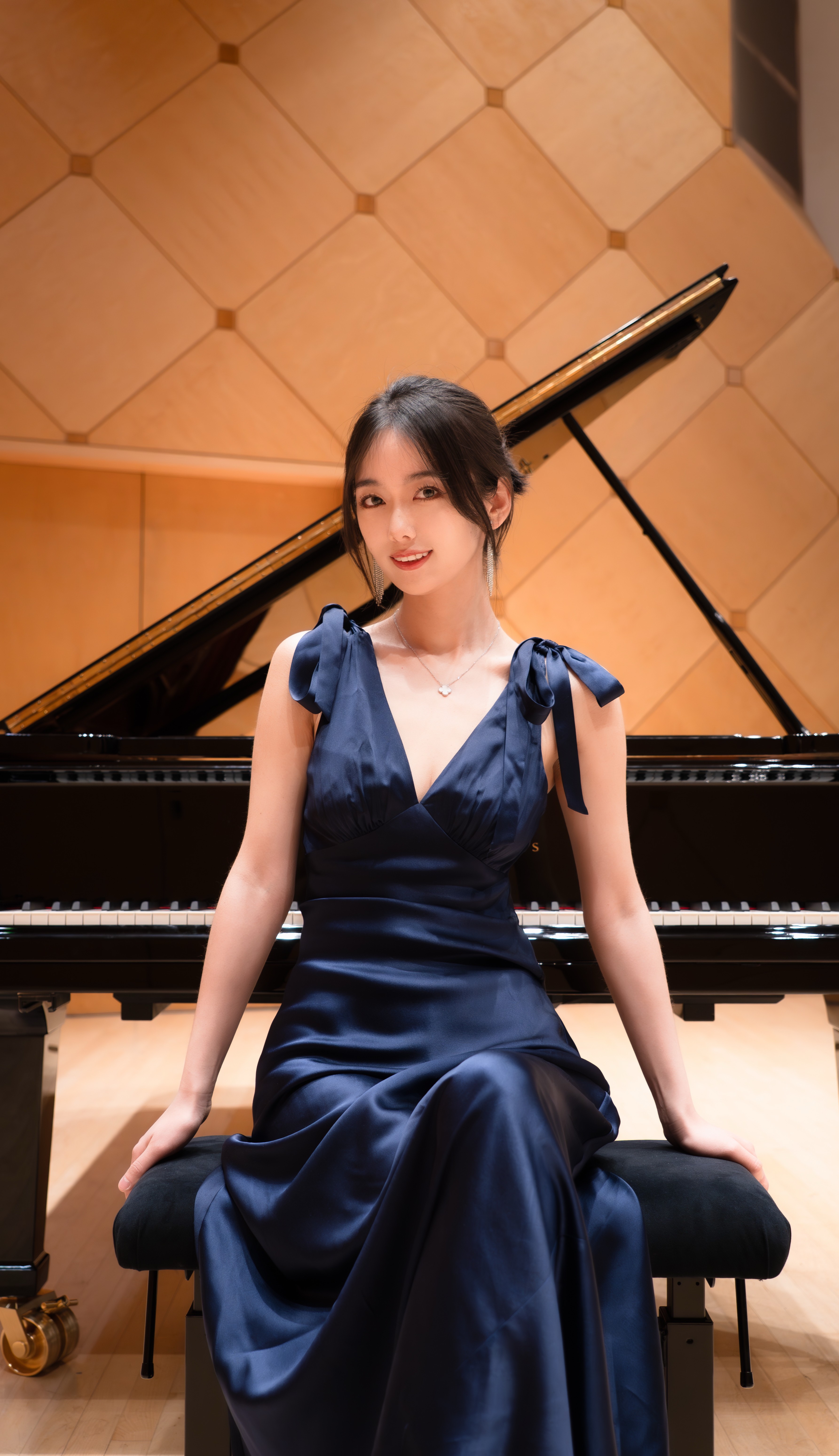 Rui Xi is sitting in front of the piano